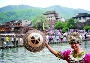 一名游客身著苗族服飾在鳳凰古城拍照